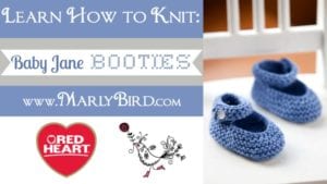 Promotional image for knitting featuring blue baby booties on a white surface, with text "Learn How to Knit: Baby Jane Booties" and logos for MarlyBird.com and Red Heart yarns. -Marly Bird