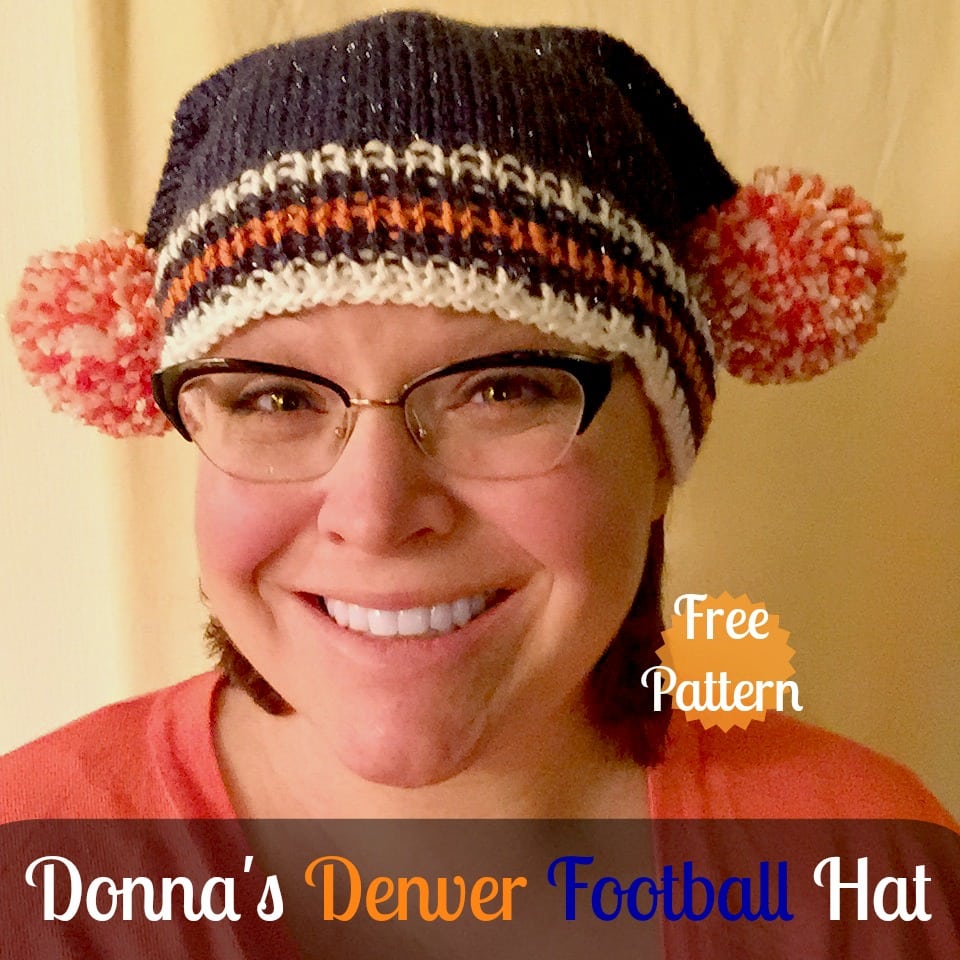 Marly wearing a navy blue hat with white and orange stripes, and 2 orange and white pompoms. Donna's Denver Football Hat - Free Pattern by Marly Bird.