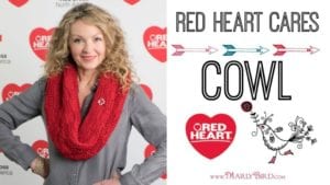 A woman with curly blonde hair wearing a red knitted cowl smiles at the camera. Next to her is a graphic titled "RED HEART CARES COWL" featuring arrows, a heart logo, and text mentioning Marly Bird. -Marly Bird