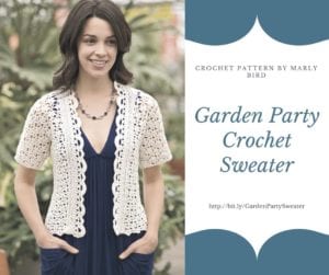 A woman smiling and wearing a white crochet sweater over a blue dress, with text promoting a "Garden Party Crochet Sweater Pattern" by Marly Bird. -Marly Bird