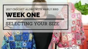 A woman presents a crochet tutorial titled "2017 Crochet Along with Marly Bird - Week One: Selecting Your Size." She stands behind colorful crochet pieces displayed on a table. -Marly Bird