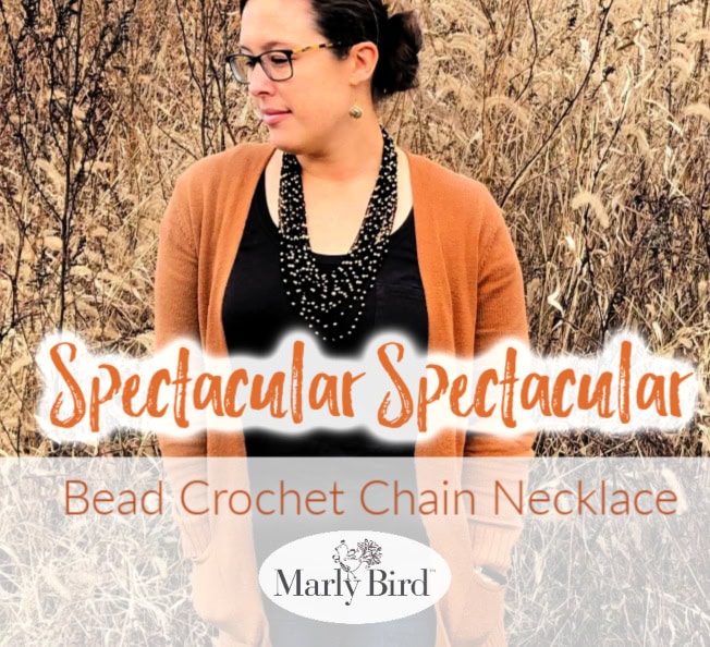 Bead Crochet Chain Necklace | Free Crochet Pattern by Marly Bird. Model wearing jeans, black scoop neck tee, and orange cardigan, with black and gold beaded crochet necklace.