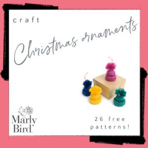 Advertisement for Marly Bird craft Christmas ornaments featuring four colorful, small knitted hats with pom-poms on top displayed around a small brown box. The text reads, "craft Yarn Scrap Christmas Ornaments - 26 free patterns!" on a pink and black background. -Marly Bird