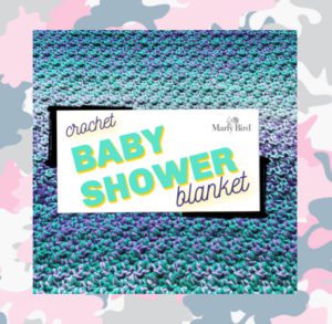 A vibrant, textured image of a double-stranded crochet baby shower blanket with a blend of blue and purple yarns. A central label reads "Crochet Baby Shower Blanket by Marly Bird. -Marly Bird