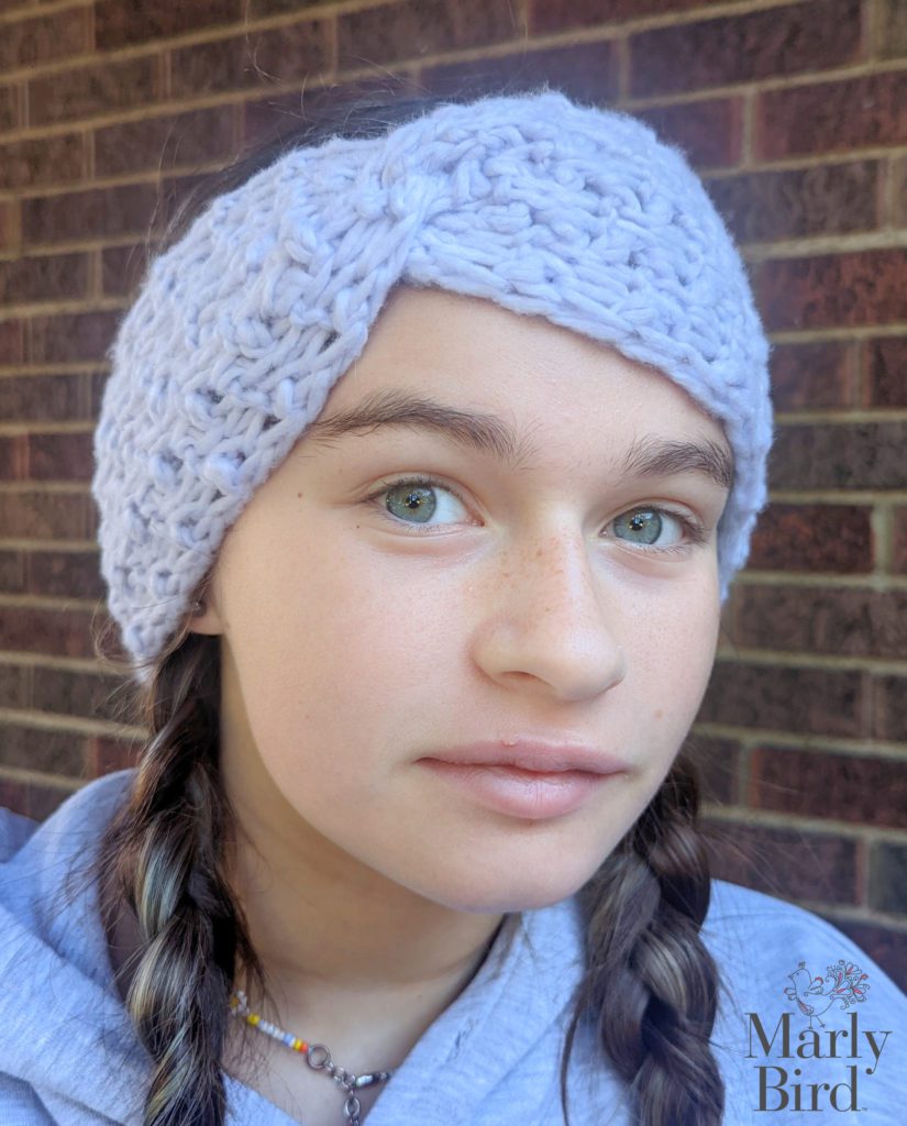 Girl wearing pigtails and asilver color Baby Boo Headband. Tunisian Crochet Lesson 2. Marly Bird