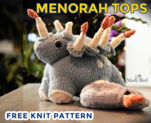 A knitted gray stuffed animal resembling a dinosaur with menorah-shaped spikes, labeled "knit menorah tops" with text "free knit pattern" by Marly Bird. -Marly Bird