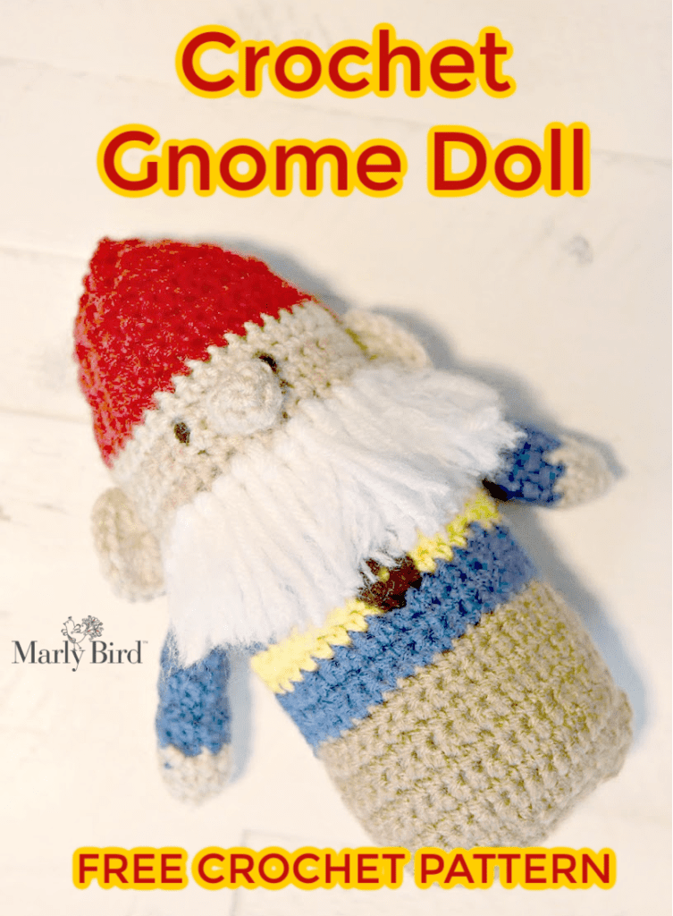 Crochet gnome doll lying flat on hard surface.