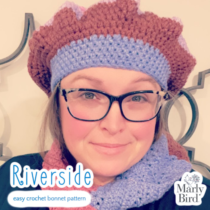 Marly Bird wearing Riverside Easy Crochet Bonnet and cowl, with pale pink and metalwork background.
