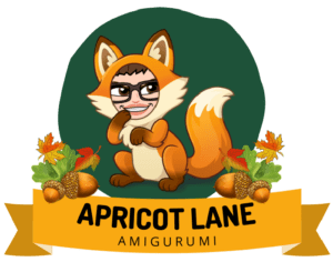 Apricot Lane Amigurumi Image. Marly Bird Bimoji in a fox outfit in a dark green circle over a banner that reads Apricot Lane Amigurumi