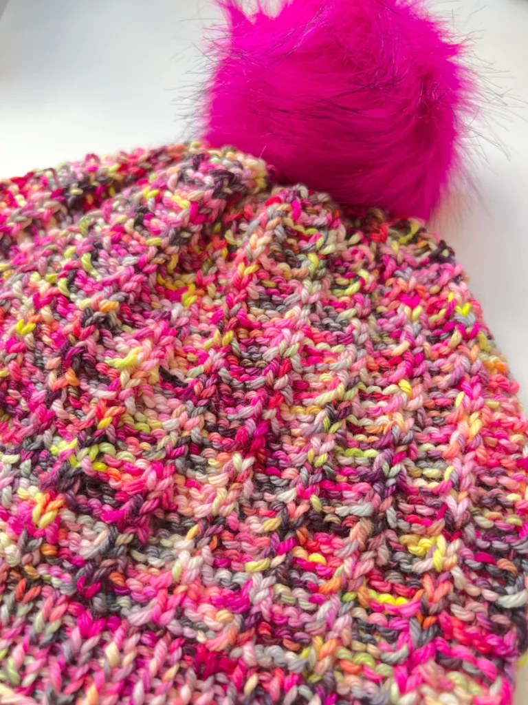 Jubilee Hat FREE PATTERN - worked in pink variegated yarn with bring pink fur pompom.