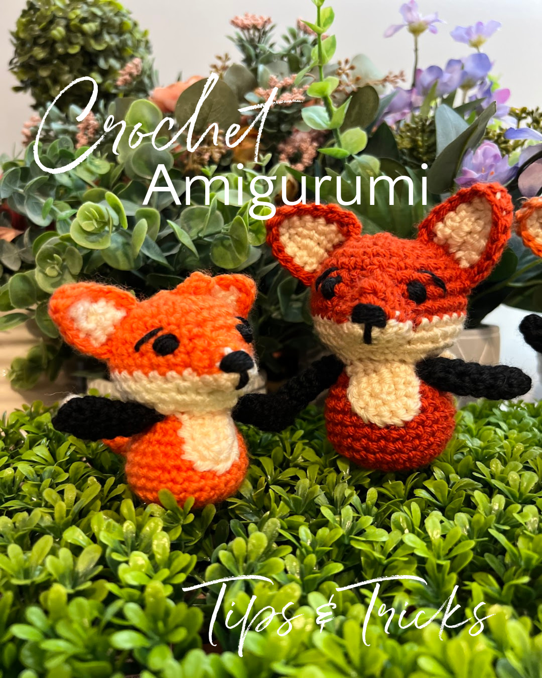 Two small crochet amigurumi foxes sitting on green leaves with green leafy background - Marly Bird.