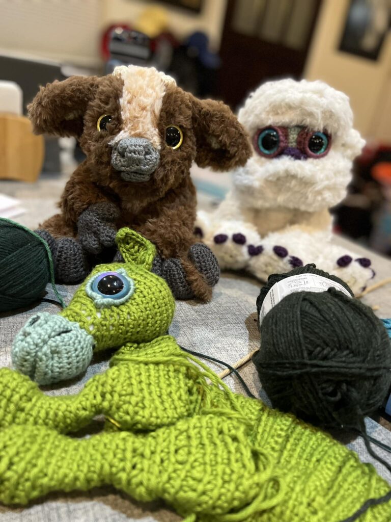 Baby Beasts to Crochet works in progress image by Megan Kreiner. pieces of the Kelpie are in progress as the Minotaur and the snowman watch. 