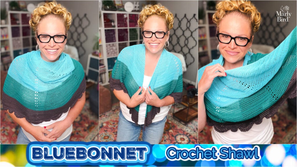 Person models a blue and dark gray crochet lace shawl, showing stitch detail and drape; colorful background with shelves behind.
