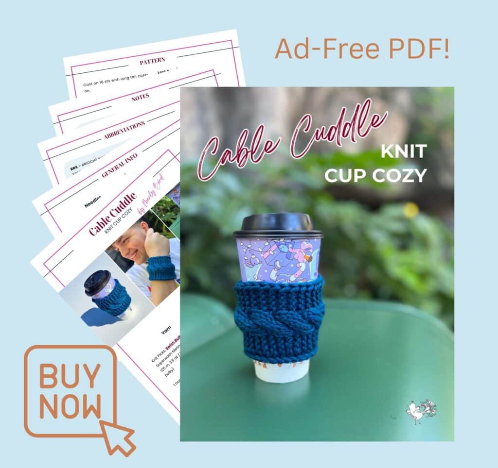 Blue cable-knit coffee sleeve on a to-go cup, shown with printed pattern pages. Visible stitches highlight knit texture.