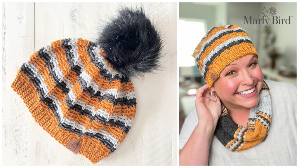 A smiling woman wearing a matching set consisting of a striped orange, black, gray, and white knit-look beanie with a black pom-pom and a coordinating neck warmer. The set is displayed separately on the left against a white surface. The Marly Bird logo is in the top right with details for the free pattern. -Marly Bird