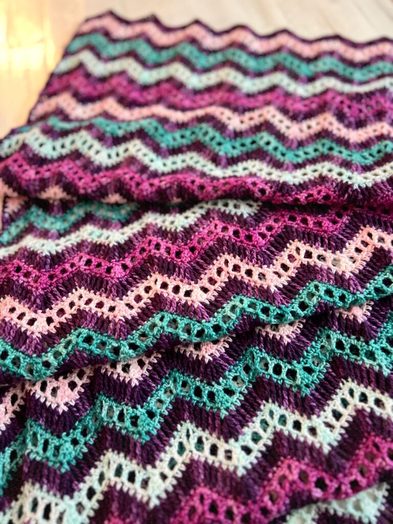 Close-up of chevron crochet shawl in multiple colors. Crochet with fingering weight yarn. Marly Bird.