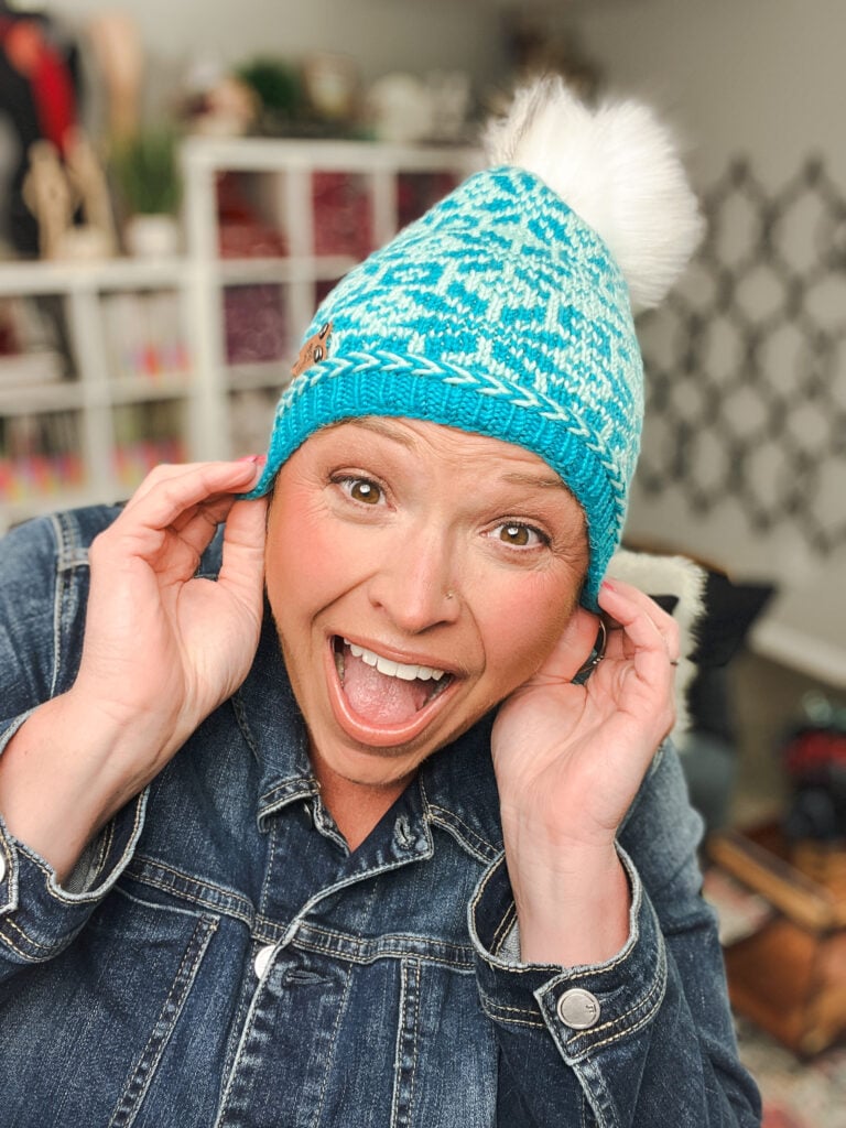 chill out winter kit hat pattern with fluffy white pom pom and a Latvian Braid detail around the brim