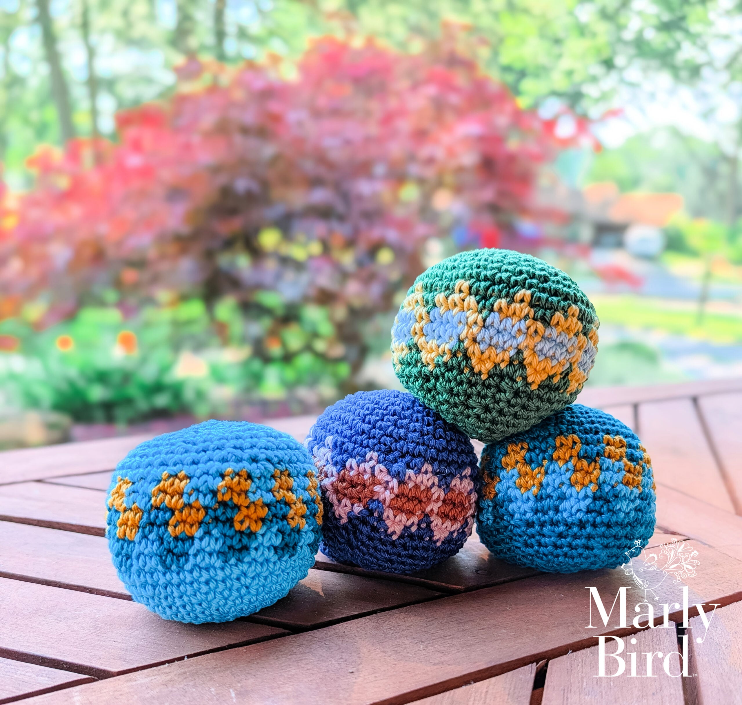 Stitch Kickers crochet hacky sack - all four colorway options displayed together on outdoor wooden deck