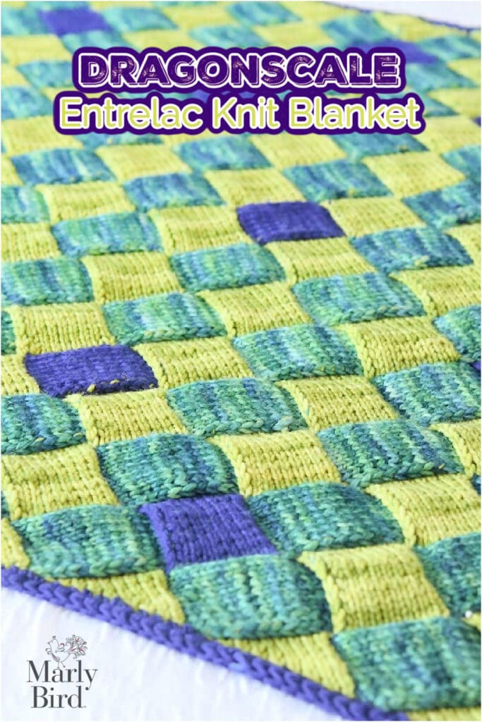 A close-up of a green, yellow, and purple checkerboard-patterned blanket with the text "DRAGONSCALE Entrelac Knit Blanket" at the top and "Marly Bird" at the bottom. -Marly Bird