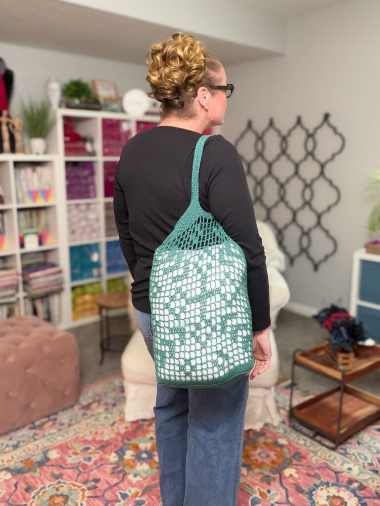 Marly Bird modeling the Farmer's Market Filet Crochet Bag, showing filet crochet stitch detail and integrated handles.