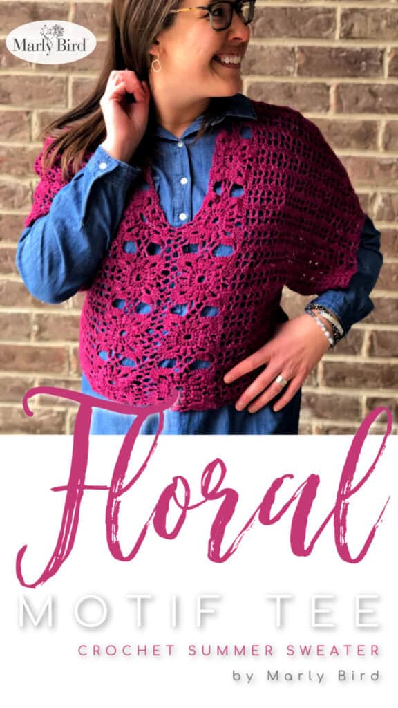 A woman wearing glasses and a denim shirt smiles while modeling a magenta floral crochet top in front of a brick wall. Text reads "Floral Motif Tee, Crochet Summer Sweater by Marly Bird. -Marly Bird