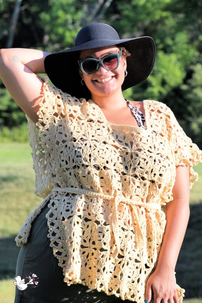 Light yellow crochet swimsuit cover-up features airy, openwork stitches and relaxed fit, modeled outdoors amid greenery.