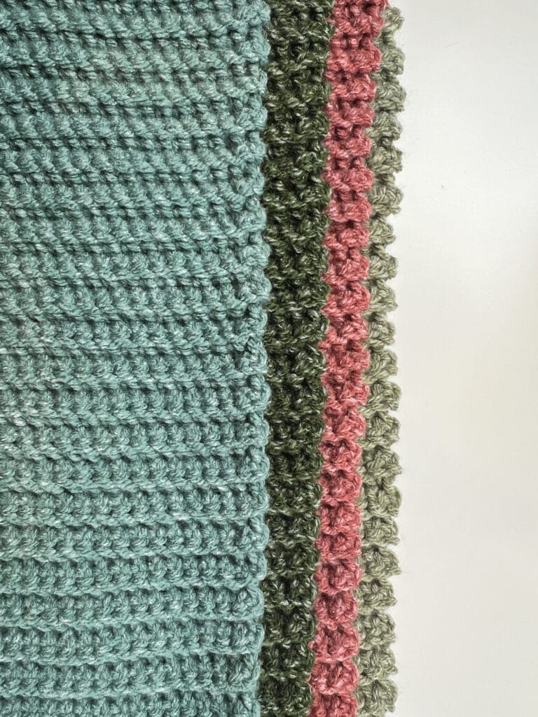 A close-up of a crocheted fabric featuring stripes in blue, green, pink, and grey evokes the vibrant spirit of game day. The texture reveals tightly woven stitches, beautifully displayed on a white background. -Marly Bird