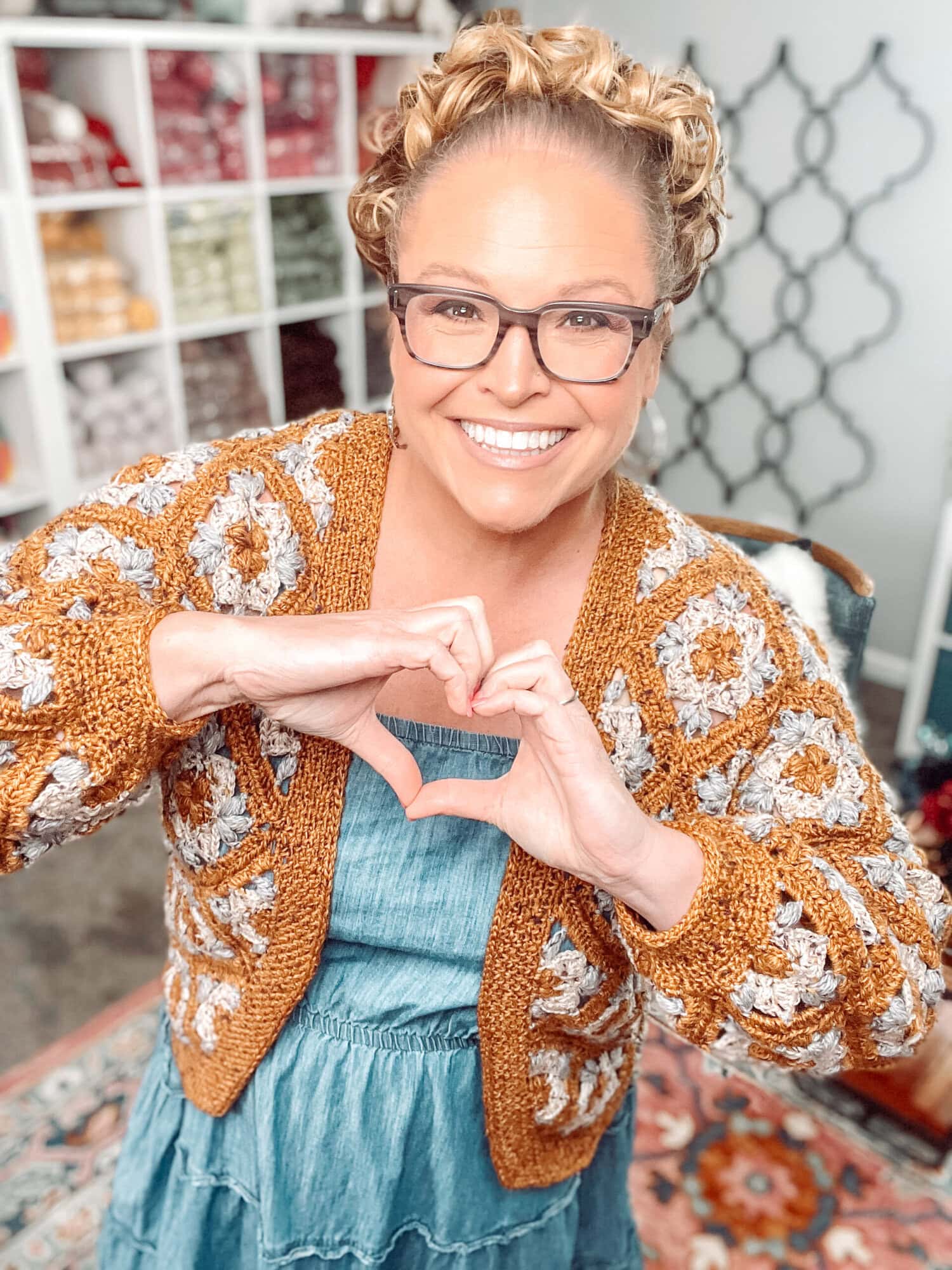 A woman making a heart with her hands. -Marly Bird