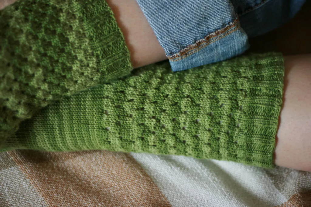 Bright green knitted scarf, detailed texture, cozy hand-knit accessory.