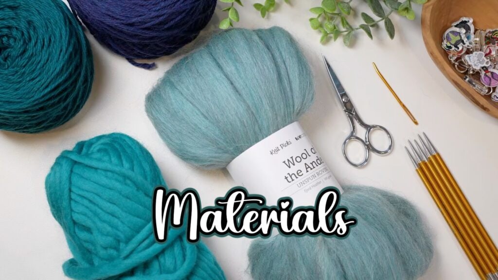 Yarn balls, knitting needles, small scissors, a metal crochet hook, a plant, and stitch markers arranged on a table with "Materials" in bold script—perfect for starting your Andes Thrummed Knit Mittens Make-Along or using a free knitting pattern. -Marly Bird
