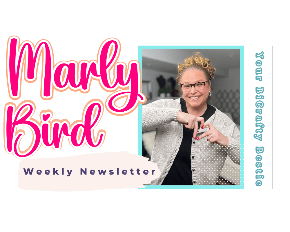 A smiling person with curly hair and glasses forms a heart shape with their hands. Behind them, the text reads "Marly Bird," "Weekly Newsletter," and "Your BigCrafty Bestie." Sporting a light cardigan, they share the joy of an amigurumi free crochet animal pattern. -Marly Bird