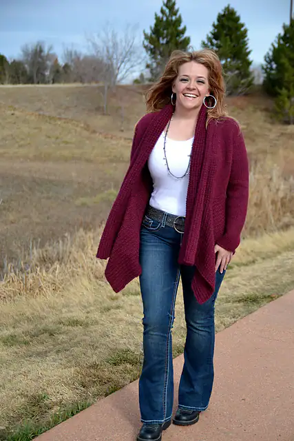 A woman smiling at the camera, delighted to share her latest creations made from free knitting and crochet patterns. -Marly Bird