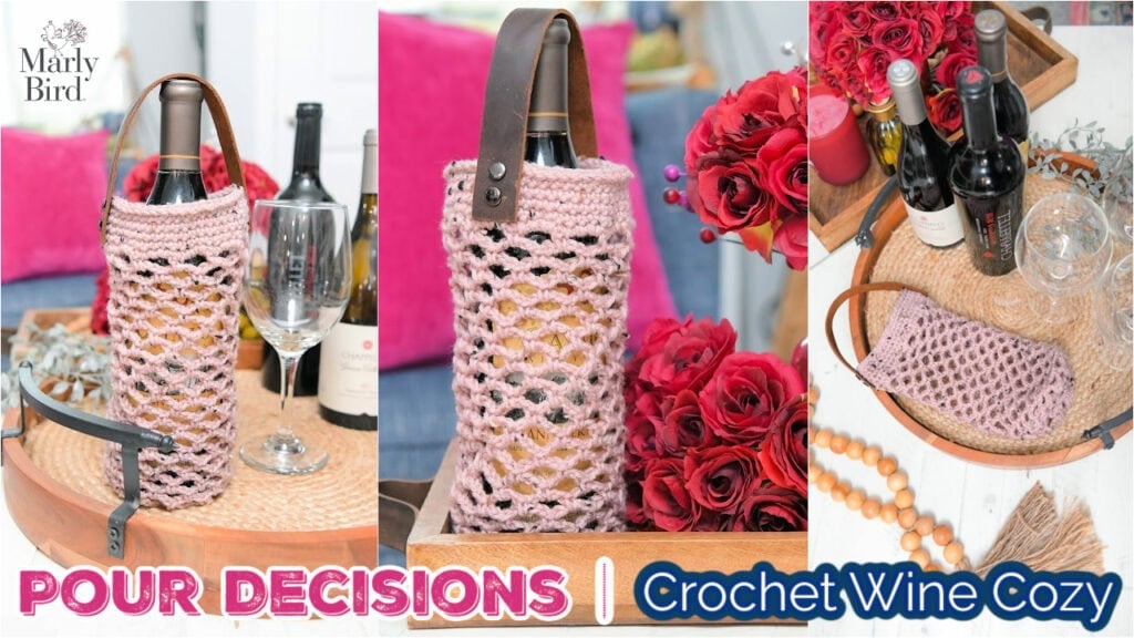 Pink crochet wine cozy with leather strap, displayed on a tray with red roses. Features textured stitches and sturdy handle.