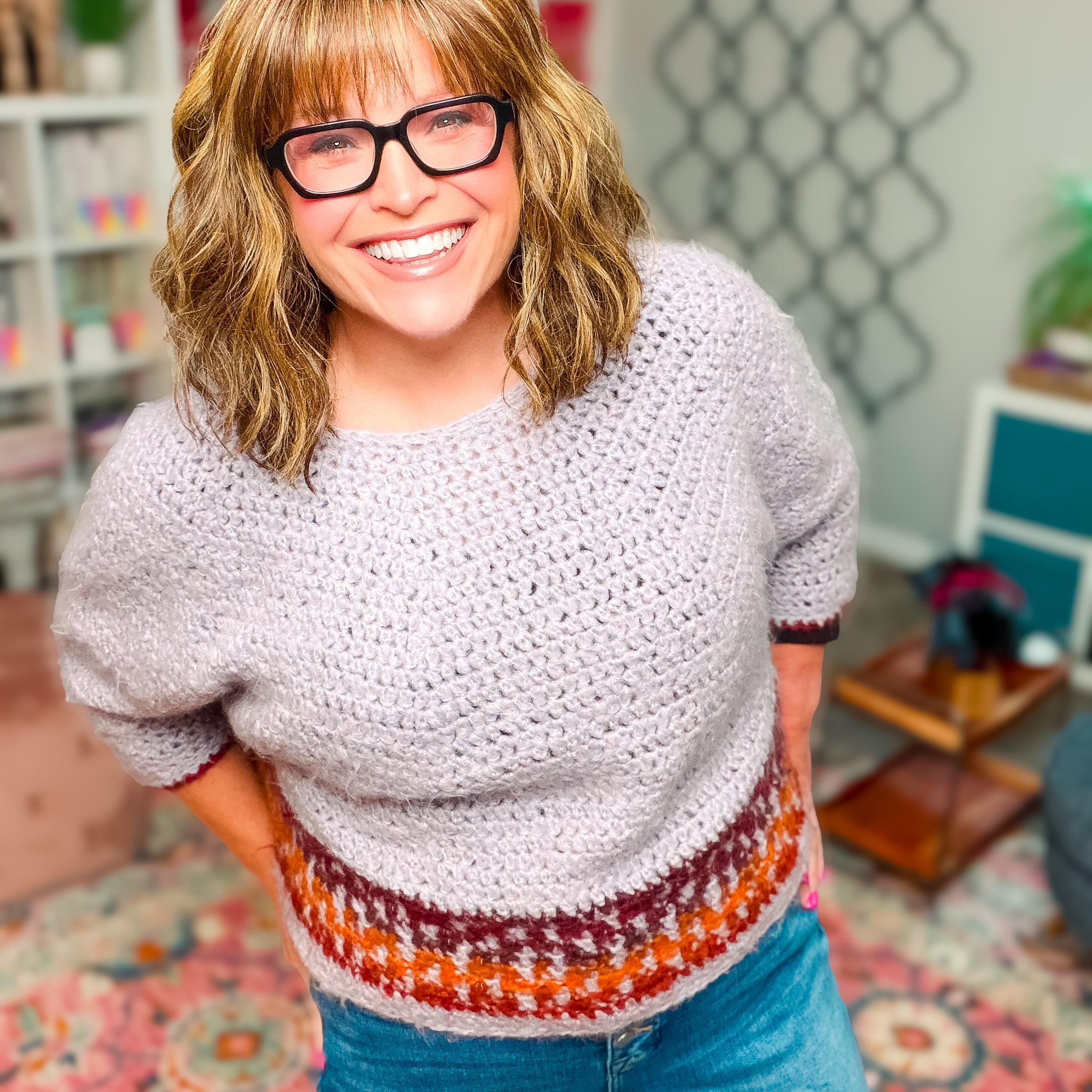 Marly Bird wearing a crochet sweater made with bulky yarn and mosaic stitches around the hem