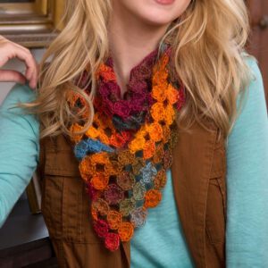 A woman wearing a colorful crocheted scarf and a brown jacket. Only her lower face and chest are visible. The scarf features a detailed yo-yo pattern. -Marly Bird