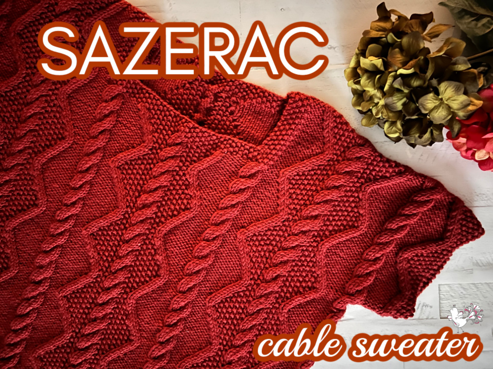 
This is an image featuring a richly textured, rust-red cable knit sweater laid out flat on a white surface. The sweater is presented with one sleeve gently folded in, showcasing the intricate cable patterns that run throughout the garment. Above the sweater, the word "SAZERAC" is written in bold, white font with a slight orange glow, followed by "cable sweater" in a smaller white font. To the right, there's a hint of floral decoration with dried hydrangea flowers in muted green and pink tones, adding a soft, autumnal feel to the composition. The photograph captures the cozy texture and detail of the knitwear, emphasizing the craft and design of the Sazerac Cable Sweater. - Marly Bird