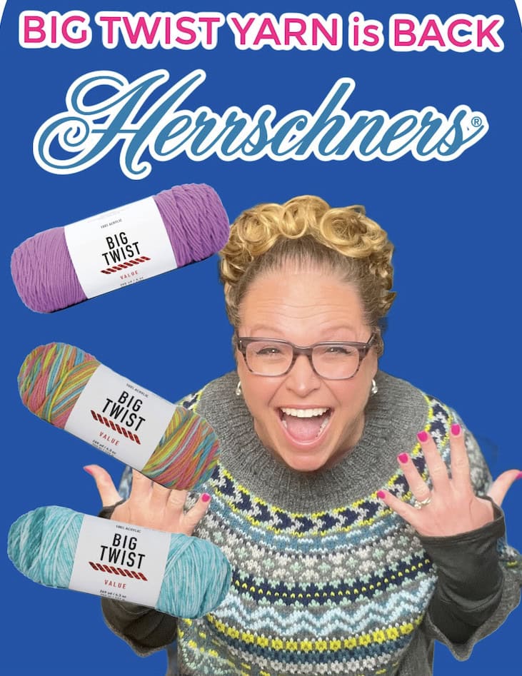 A smiling woman in glasses and a patterned sweater holds her hands up excitedly in front of colorful Big Twist Yarn skeins, celebrating its return at Herrschners, with “BIG TWIST YARN is BACK” and the Herrschners logo in the background. -Marly Bird