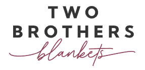 Logo with the words "TWO BROTHERS" in bold black uppercase letters above the word "blankets" in a cursive, mauve font, perfect for events like the 24 Days of Quickies. -Marly Bird