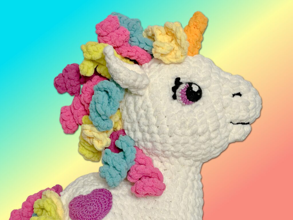 Sparkle the crochet unicorn on rainbow background - Marly Bird