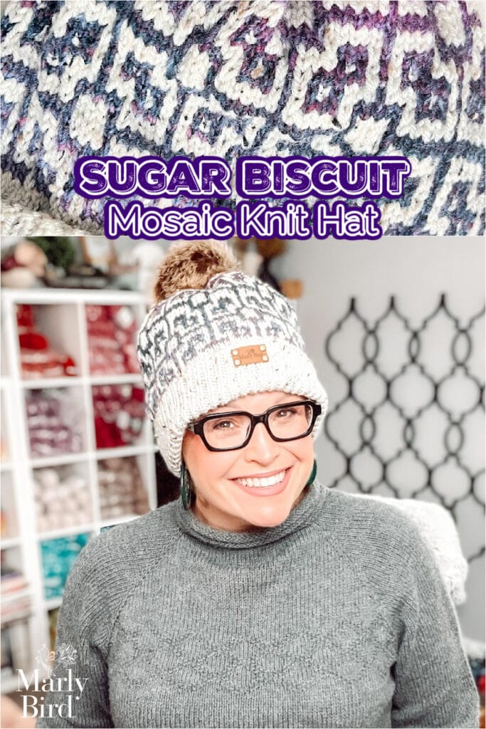 A smiling woman wearing glasses and a cozy, patterned knit hat with a pom-pom stands indoors. Text reads "Sugar Biscuit Mosaic Knit Hat," featuring the Marly Bird Knit Hat Pattern. A closeup highlights the hat's intricate knit design above her. -Marly Bird