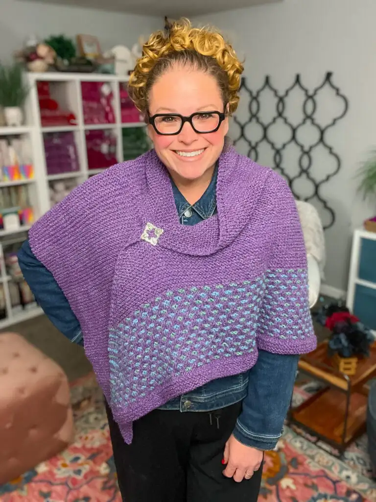 A person models the Marly Bird Summit Knit Shawl, showing its delicate stitch detail and drape over a denim shirt. Summit Knit Shawl free garter stitch knit shawl pattern