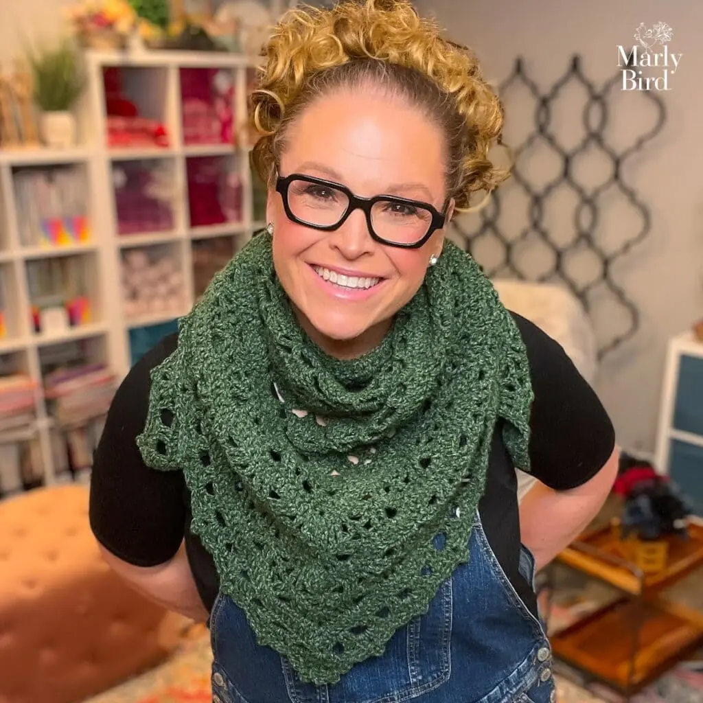 Sunday Sideline crochet beginner triangle shawl by Marly Bird worn styled with denim jacket in forest green yarn