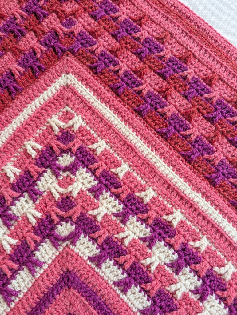 Colorful crochet blanket with bold geometric patterns and detailed textured stitches, inspired by Tournament of Stitches 2026.