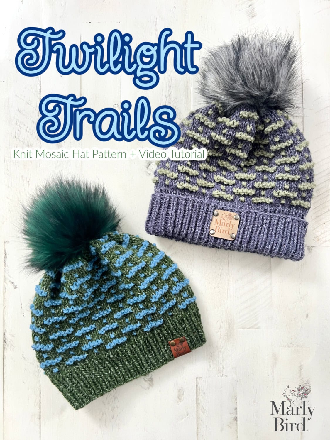 Two knit mosaic hats with pom-poms rest on a light wooden surface. One hat is green with blue patterns; the other is blue with gray patterns. Both feature leather-like tags. Text reads "Twilight Trails," and "Knit Mosaic Hat Pattern + Video Tutorial" by Marly Bird. -Marly Bird