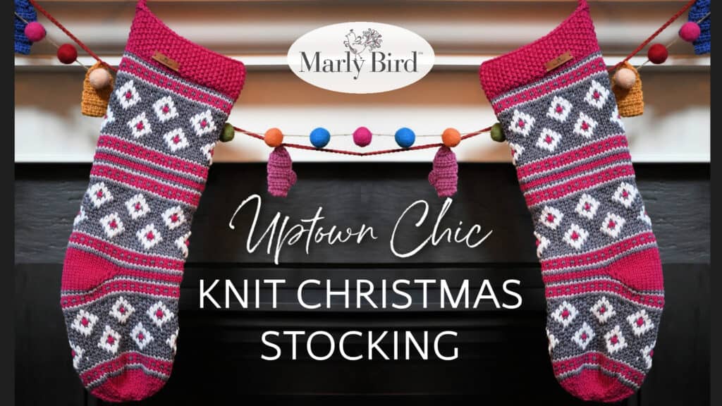 Two vibrant knit Christmas stockings dangle elegantly from a mantle, adorned with a cheerful garland of pom-poms and tassels. "Uptown Chic Knit Christmas Stocking" graces the text, topped with the distinctive "Marly Bird" logo. -Marly Bird