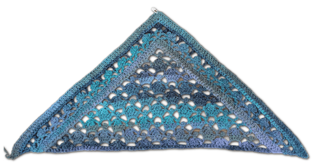 A lacy blue and gray crocheted triangular shawl with openwork stitches and a metal ring at the top corner on a white background.