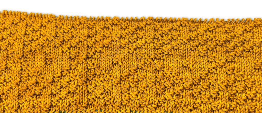 Yellow knitted fabric in a diagonal knit and purl pattern; unfinished edge shows loose stitches on white background.