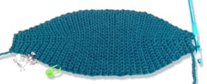 crochet blue oval swatch with visible stitches, blue hook on right, green marker left, bird illustration bottom left.