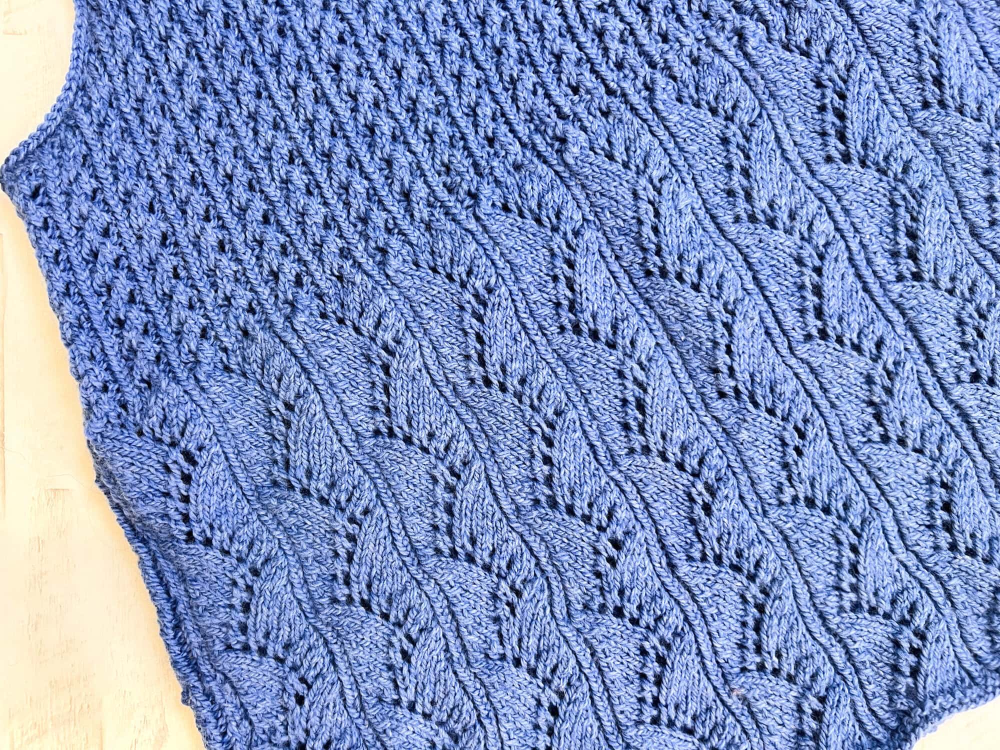 Close-up flat lay detail of the Thistlevine knit tunic vest showing the Zig Zag Waves lace peplum hem stitch pattern and Lace Columns transition by Marly Bird