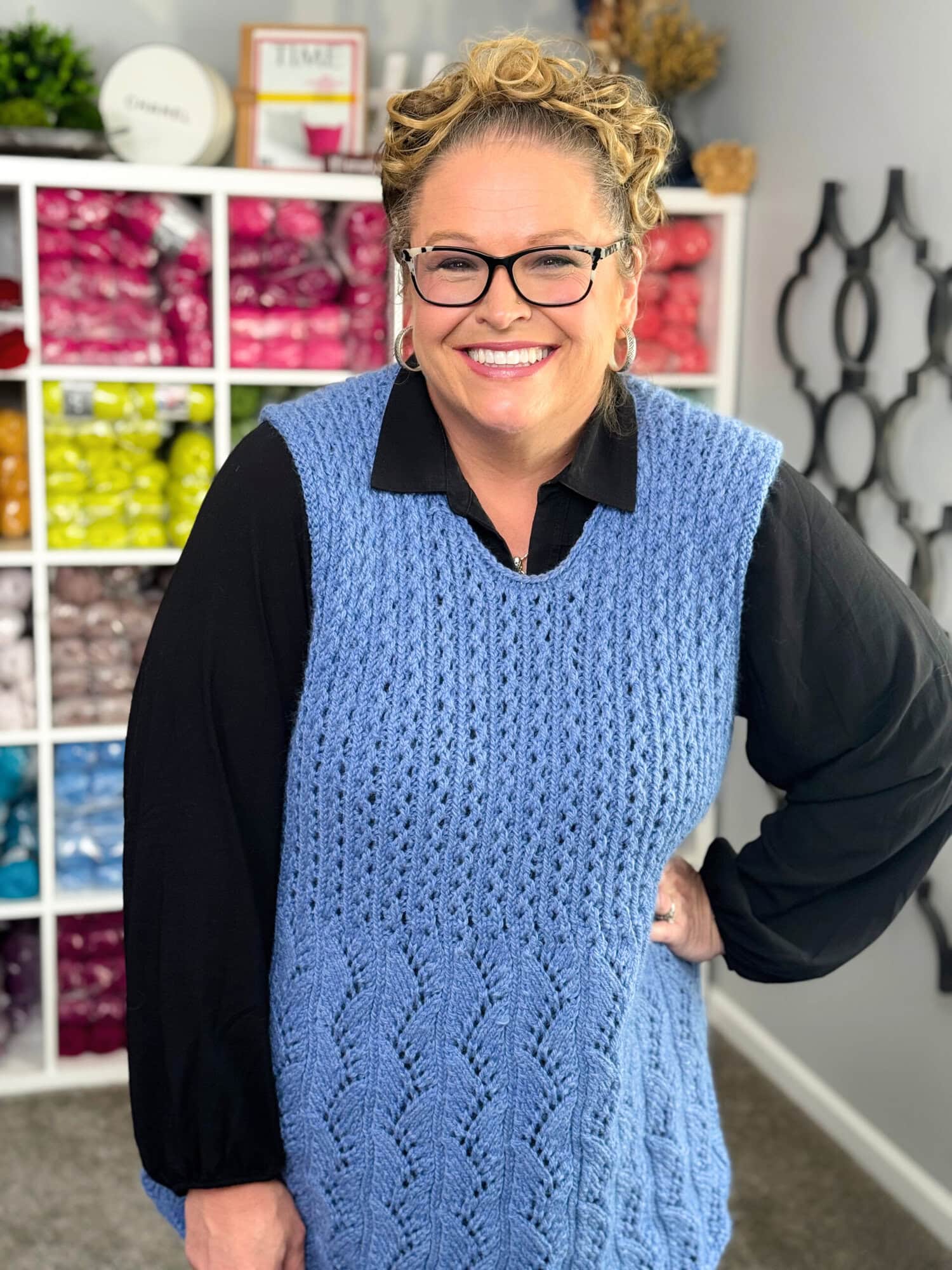 Marly Bird wearing the Thistlevine free knit tunic vest pattern over a white collared blouse, showing the neckline finish and Lace Columns bodice texture